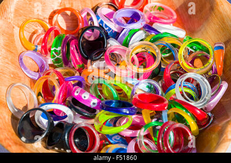 Colorato glas anelli in una scatola di legno sono offerti in vendita al settimanale mercato delle pulci a parte il fiume Elba Foto Stock