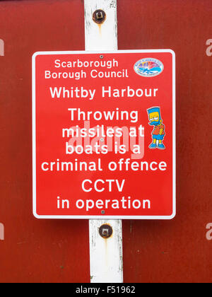 Scarborough Borough Consiglio segno di avvertimento a Whitby Harbour lanciando missili a barche è un reato penale CCTV in funzionamento Foto Stock
