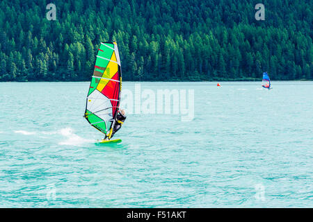 Un surfista sta attraversando il Lej da Silvaplana, una alta altitudine lago vicino a st. moritz Foto Stock