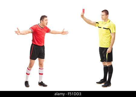 A piena lunghezza Ritratto di un arbitro di calcio che mostra il cartellino rosso per un lettore arrabbiato isolati su sfondo bianco Foto Stock