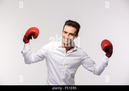 Ritratto di un happy businessman in maglietta indossa in rosso i guantoni isolato su uno sfondo bianco Foto Stock