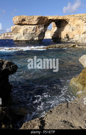 Una grande apertura attraverso un promontorio roccioso sulla costa di Gozo, una delle isole maltesi. Foto Stock