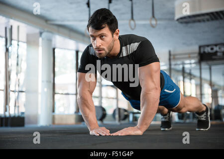 Atleta indossa pantaloncini blu e nero t-shirt fare esercizio per i bracci Foto Stock