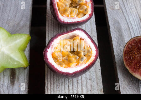 Frutti della passione, carambole vicino, prugna e un altro frutto della passione, sulla massa di legno Foto Stock