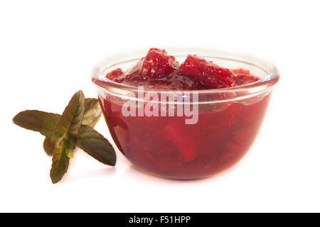 Un vaso di vetro pieno di rabarbaro marmellata, isolati su sfondo bianco Foto Stock