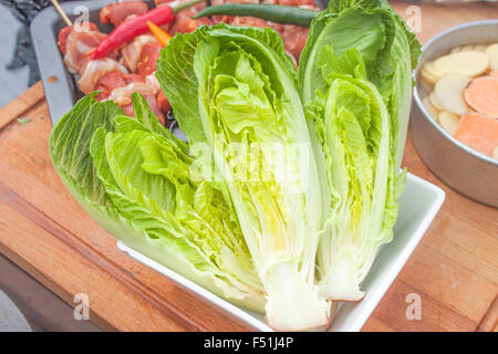 Insalata Romaine la metà, in attesa di essere grigliate. Nei pressi di spiedini di carne e verdure Foto Stock