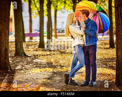 Amare giovane a piena altezza su una data baciare sotto l'ombrello. Foto Stock
