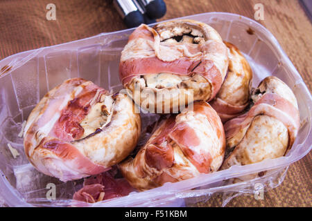 Una scatola piena di riempito gli champignon, farcite con bluecheese, marinato con balsamico e avvolto in pancetta Foto Stock