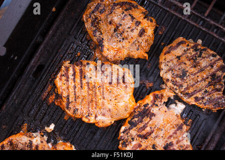 Grigliare carne di maiale bistecche di collo su un barbecue Foto Stock