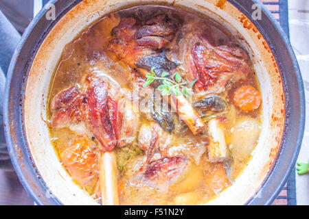 Uno stufato pieno di gustosi gambo di agnello, erbe aromatiche e carote Foto Stock