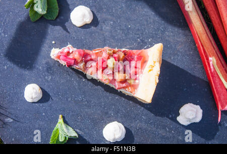 Una fetta di torta di rabarbaro, tra pannacotta e menta Foto Stock