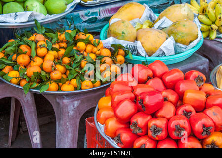 Un sacco di rosso fresco persimons, Diospyros scolorire, in un mercato di Phu Quoc, Vietnam Foto Stock