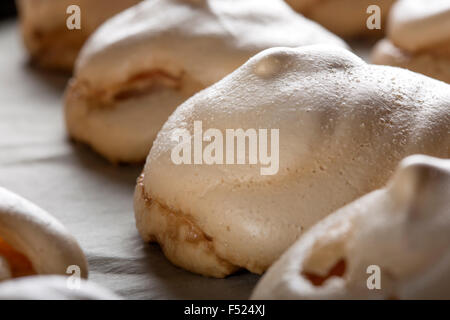 Bianco cotto meringhe pila sul vassoio da forno Foto Stock