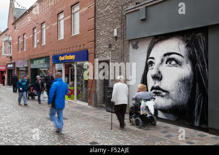 Persone che passano in bianco e nero ritratto; arte urbana o graffiti a Blackpool, Lancashire, Regno Unito pedone passato walking street art graffiti dipinti a muro,. Foto Stock