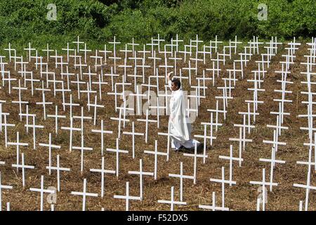 Tacloban, Leyte, Filippine. 8 Novembre, 2014. Un prete cattolico benedice il 3.000 croci bianche in corrispondenza di una fossa comune sito in Vasper, Tacloban City. È stata celebrata una Santa Messa per ricordare coloro che sono morti durante il tifone Haiyan ha colpito la Visayas lasciando 6.000 morti e migliaia di senzatetto il 8 novembre 2013. © Linus Escandor Ii/ZUMA filo/ZUMAPRESS.com/Alamy Live News Foto Stock