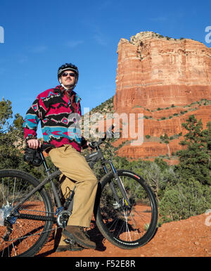 Ciclista sulla campana percorso di roccia di fronte Courthouse Butte nel villaggio di Oak Creek Foto Stock