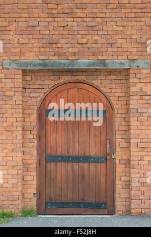 La porta di legno con un muro di mattoni Foto Stock