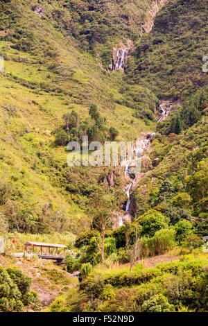 Una cascata a più livelli scorre lungo una ripida montagna rocciosa coperta da una fitta vegetazione verde. La cascata si divide in diversi ruscelli mentre scende attraverso la valle, circondata da un mix di Foto Stock