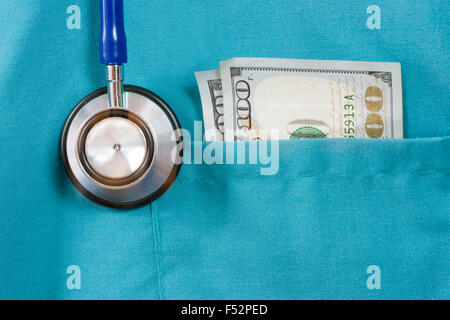 Medico top scrub con uno stetoscopio e un centinaio di dollari. Foto Stock