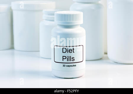 Bianco pillola di dieta con contenitore PILL contenitori in background. Foto Stock
