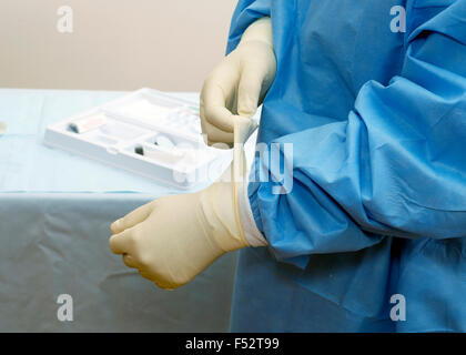 Chirurgo mettendo su guanti sterili prima dell'operazione. Foto Stock