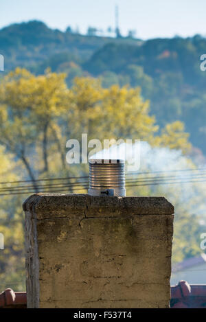 Fumo proveniente dal camino di una casa Foto Stock