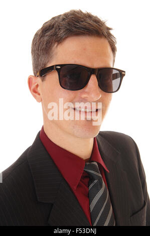 Una foto ritratto di un giovane uomo di affari in un vestito e cravatta, indossando occhiali da sole scuri e sorridente, isolato per sfondo bianco Foto Stock
