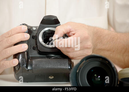 Stretta di mano del fotografo sensore di pulizia della sua fotocamera Foto Stock