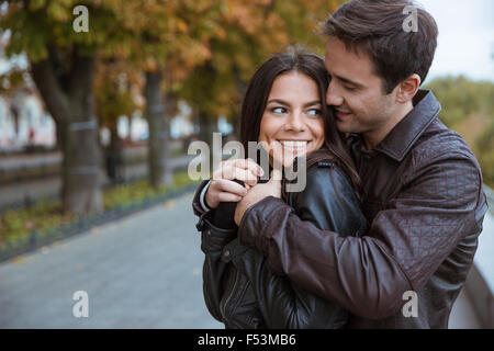 Ritratto di una felice coppia giovane flirtare in autunno park Foto Stock