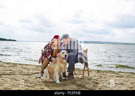 Seniors strofinarsi il cane e godendo di autunno Meteo Foto Stock