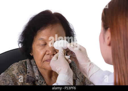 Medico del bendaggio occhio del paziente su sfondo bianco Foto Stock