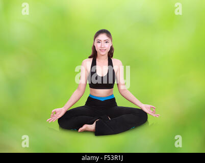 Giovane donna facendo esercizio di yoga con naturale sfocatura sullo sfondo Foto Stock