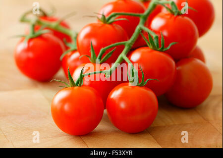 Pomodoro ciliegino "Conchita " frutti ". Di coltivazione biologica, pomodori ciliegia su un tagliere. Foto Stock