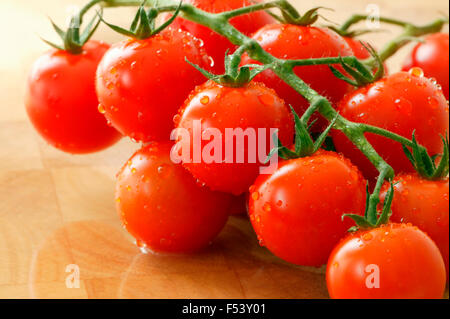 Pomodori ciliegini "Conchita' Fruit" coltivati organicamente, pomodori ciliegini su un tagliere Foto Stock