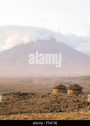 Villaggio masai di fronte all'Ol Doinyo Lengai nella Regione di Arusha, Tanzania Africa. Foto Stock