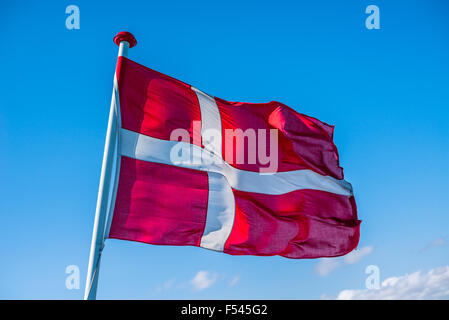 Bandiera danese nel vento su sfondo blu Foto Stock