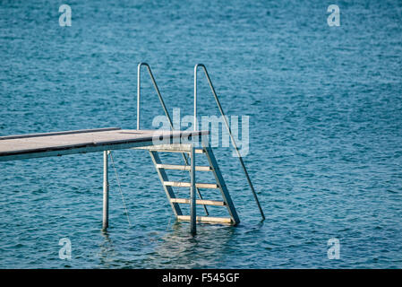 Pontile con una scala a pioli in un oceano blu Foto Stock