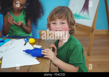 Piccolo boy utilizzando di arti e mestieri e materiali di consumo Foto Stock