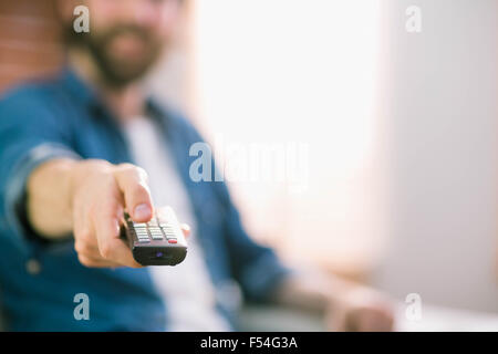 Uomo informale di guardare la TV sul divano di casa Foto Stock