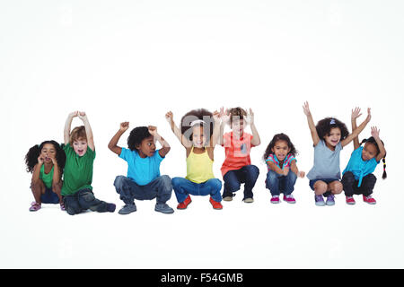 Una fila di bambini accovacciato insieme Foto Stock