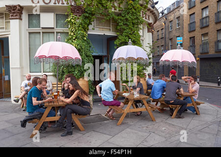 La gente seduta al di fuori della Taverna commerciale pub in Shoreditch, Londra England Regno Unito Regno Unito Foto Stock