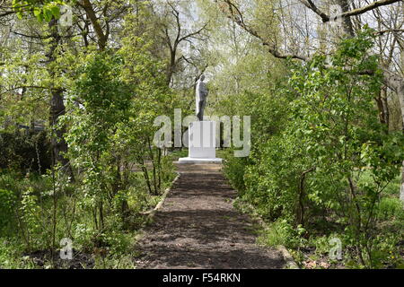 Antica statua di Lenin si affaccia dalle boccole Foto Stock