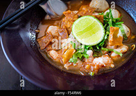 Thai piccante tagliatelle tom yum zuppa con carne di maiale e di limone topping sul cibo di strada in Thailandia Foto Stock