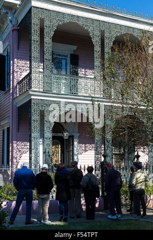 Gruppo di Tour a grand mansion house ornati in ferro battuto traforature gallery, il Garden District, New Orleans, Louisiana USA Foto Stock