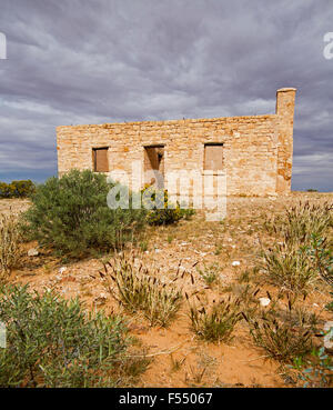 Rovine di storico del XIX secolo Carcory homestead, cottage in pietra circondato da piante native sotto il cielo tempestoso, outback Australia Foto Stock