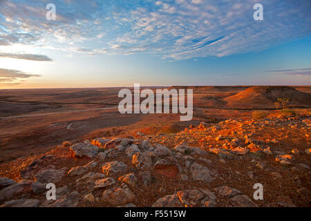 Incredibile outback australiano il paesaggio dalla collina lookout al tramonto, rocky mesas su vasta brulle pianure brulla allungamento all' orizzonte lontano Foto Stock