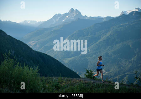 Donna di jogging sul percorso in mountain range Foto Stock