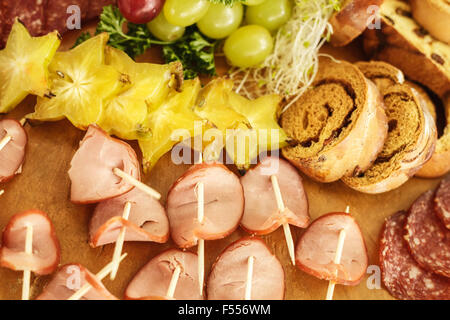 Il servizio di catering con vari frutti e salsicce su legno Foto Stock