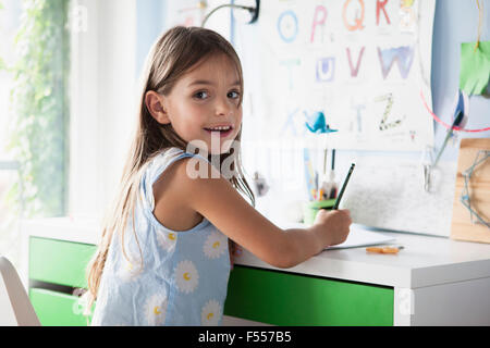 Ritratto di felice ragazza studiare alla scrivania Foto Stock