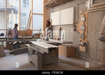 Maschio e femmina di falegnami di lavoro in officina Foto Stock